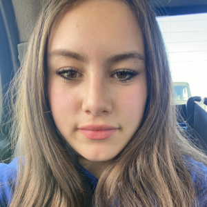 Selfie of a young woman in a car.