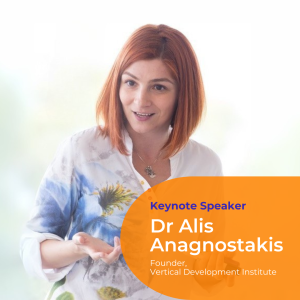 Portrait photo of Dr Alis Anagnostakis with a bright white background. She wears a white and blue floral shirt and has bright red hair cut into a bob.