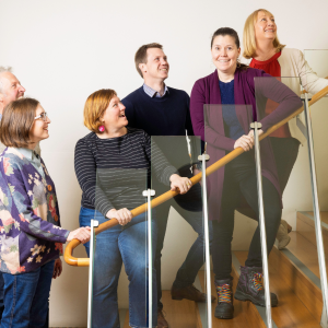 6 graduates from 2024 Tasmanian Leaders Program on a wooden staircase. All smiling happily and looking up the stairs. Two men and four women are in the photo.