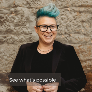 Head shot of Katy Cooper. Katy has a black jacket and short spikey green hair and glasses