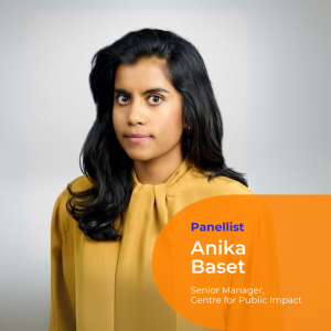 A portrait photo of Panellist Anika Baset wearing a long sleeve mustard shirt, long black hair. She is looking intently at the camera.