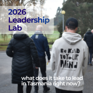 a group of people dressed in warm clothing walking outdoors in a loose line, backs to the viewer